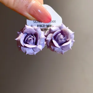 Close-up of purple resin rose flower stud earrings with intricate petal detail