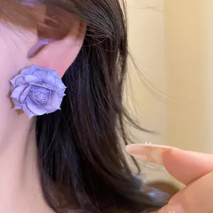 Detailed view of an elegant purple resin rose earring being worn on a model's ear