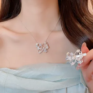 Primo piano di collana a farfalla in zircone e set di fermagli per capelli con fiori.