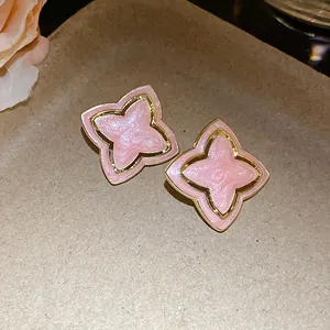 Detailed close-up of pink dripping oil star-flower earrings with vintage gold border