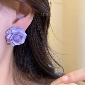 Detailed view of a purple resin rose stud earring worn on an ear for a stylish look.