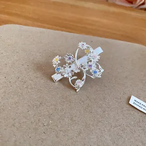 Dettaglio di un'elegante fermaglio per capelli a farfalla d'argento con fiori di zircone colorati