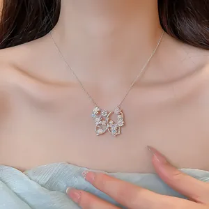 Dettaglio di un'elegante collana con ciondolo a farfalla e fiori in zircone
