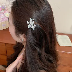 Elegante molletta per capelli in zircone con farfalla e fiori su capelli castani