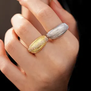 Dettaglio di due anelli testurizzati placcati oro 14k con pavé di zirconi sulla mano