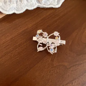 Primo piano di un fermaglio per capelli in argento con farfalla e fiori di zircone