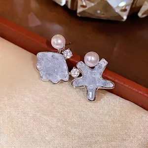 Asymmetric shell and star stud earrings with white pearls and shimmering zircons for women