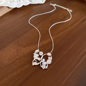Dettaglio ravvicinato della collana con ciondolo farfalla floreale in argento e zirconi