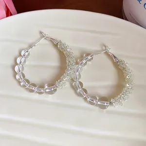 Detailed view of handmade clear glass bead hoop earrings with silver needles
