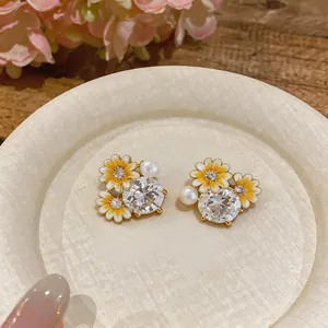 Elegant yellow daisy stud earrings with central zircon and small pearls detail
