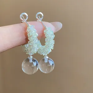 Detailed view of silver needle glass beaded hoop earrings with a clear round glass ball
