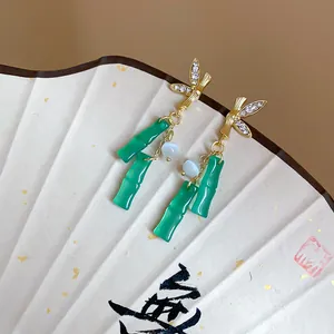 Detailed view of elegant bamboo-shaped resin tassel earrings with sparkling rhinestones