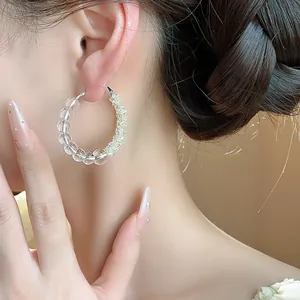 Detail shot of silver needle hoop earrings with clear glass beads and fine crystals