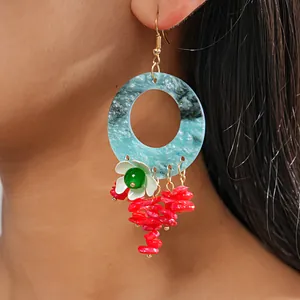 Detailed view of bohemian blue marble hoop earring featuring flower and red stone tassels