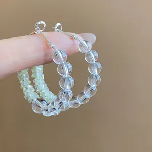 Detailed close-up showing clear round glass beaded hoop earrings on a silver wire