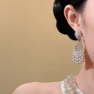 Elegant French vintage teardrop pearl earrings with zircon embellishments shown on model