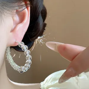 Close-up detail of elegant clear glass bead hoop earrings on ear for a minimalist look