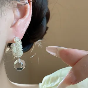 Detailed macro view of elegant sparkling glass bead earrings with a clear glass ball drop