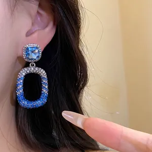 Eleganti orecchini pendenti con cristalli blu sfumati e pietra preziosa quadrata