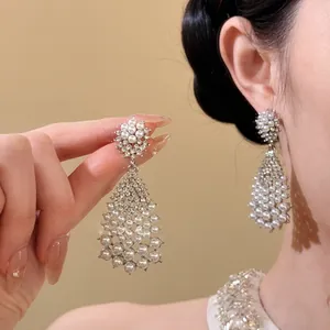 Close-up detail of silver needle zircon pearl pendant earrings with elegant vintage style