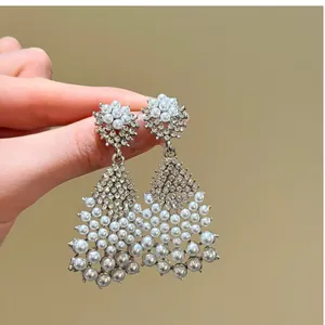 Detailed close-up of elegant teardrop earrings featuring pearls and sparkling crystals