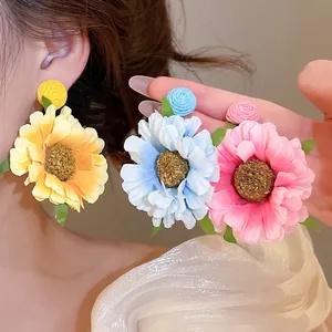 Handgemaakte stoffen madeliefjes oorbellen in geel blauw en roze voor de vakantiestijl
