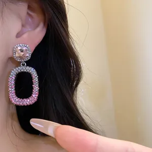 Vista dettagliata di orecchini pendenti in argento con cristalli rosa sfumati eleganti.