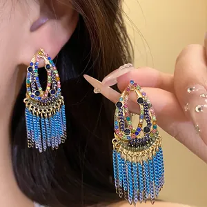 Close-up detail of Bohemian teardrop earrings with colorful stones and blue tassels
