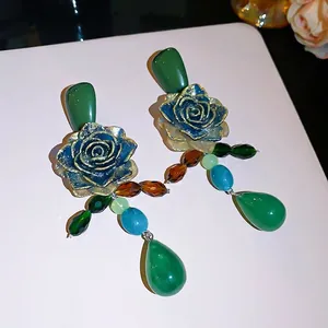 Vintage green rose dangle earrings with gold-edged resin flowers and elegant beads.