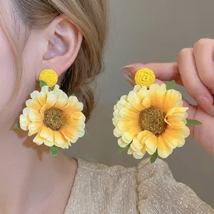 Handgemaakte stoffen zonnebloem oorbellen in geel, ideaal voor een landelijke vakantielook.