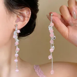 Elegant long tassel earrings featuring pink cat's eye beads and delicate silver-toned chains.
