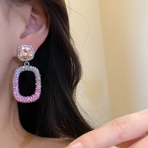 Primo piano di orecchini a pendente rettangolari rosa con strass eleganti e lussuosi
