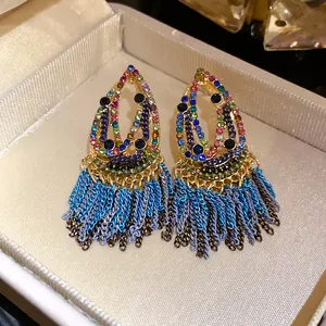 Close-up of Bohemian colorful gemstone teardrop earrings with blue tassel detail.