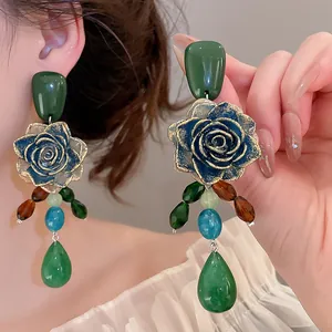 Detailed macro view of vintage green rose earrings with colorful resin bead charms