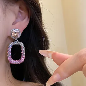 Dettaglio di orecchini pendenti rettangolari scavati con strass rosa sfumati di lusso