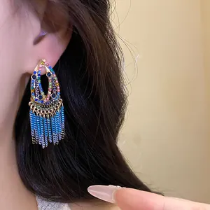 Detailed view of bohemian colorful gemstone teardrop earrings with blue metal fringe tassels