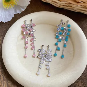 Detail view of elegant s925 silver needle cat-eye stone tassel earrings in multiple colors.