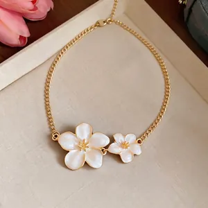 Elegant gold chain necklace featuring two delicate white enamel flower pendants for women