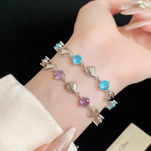 Detail showing elegant silver-tone bracelets with heart shapes and colorful zircon stones