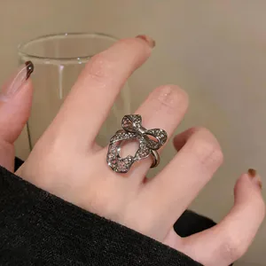 Close-up of a silver-colored hollow bow open ring on finger, elegant jewelry detail