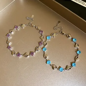 Detailed view of silver heart-link bracelets with purple and blue cubic zirconia stones