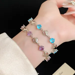 Close-up of elegant zircon bracelets with silver heart charms and colored stones