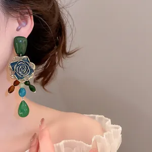Close-up view of vintage green rose earrings with multi-colored beads on a model's ear