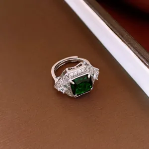 Close-up detail of a vintage silver open ring with a green square zircon gemstone