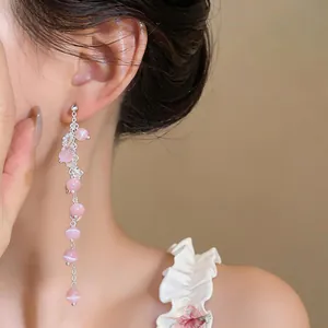 Detail of elegant pink cat's eye stone tassel earrings with a refined silver finish