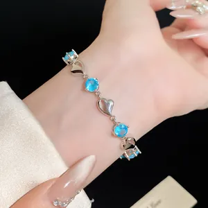 Close-up detail of silver heart bracelet with sparkling blue cubic zirconia stones