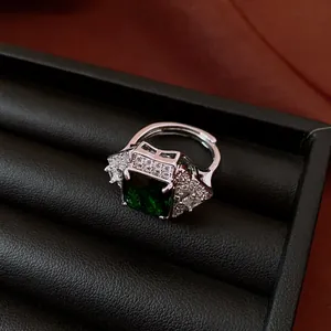 Detailed view of luxury square emerald green zircon ring with sparkling side stones