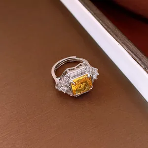 Close-up of a vintage luxury square yellow zircon open ring with sparkling side stones.