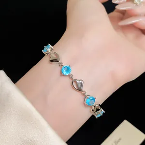 Close-up of a silver heart bracelet with sparkling light blue zircons on a wrist
