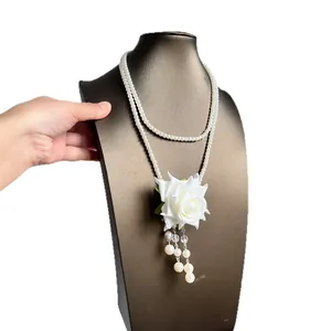 Elegant double-layered pearl necklace with white rose tassel pendant on mannequin